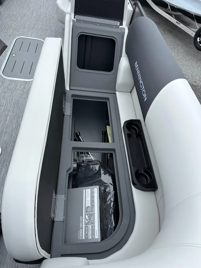 Slide: The Image of 2025 Bennington 22 SSR Tritoon storage compartment with open seat and cup holders. - 7