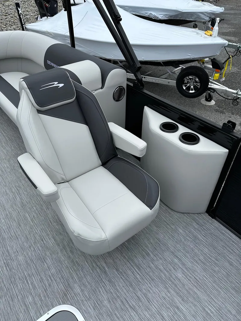 Slide: The Image of 2025 Bennington 22 SSR Quad Bench Tritoon interior with plush seating and cup holders. - 8