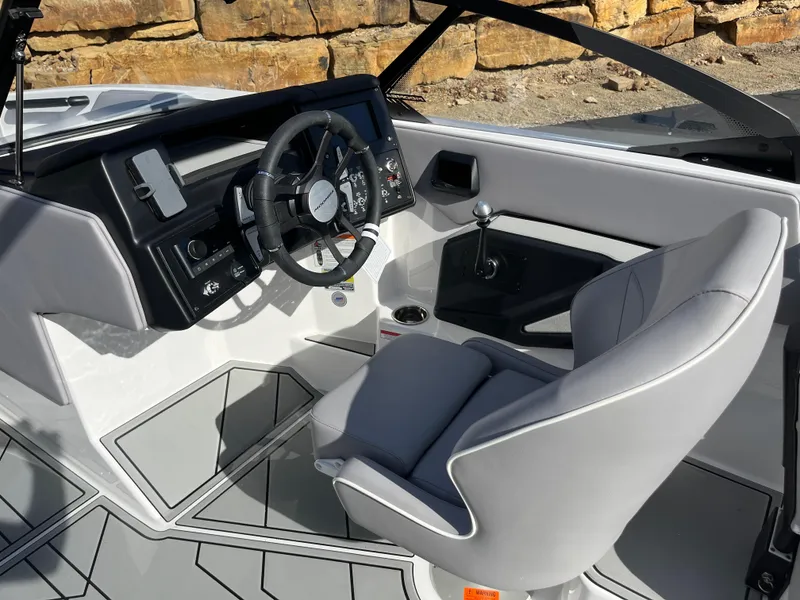 Slide: The Image of 2025 Moomba Max boat interior with modern steering wheel and sleek gray seating. - 11