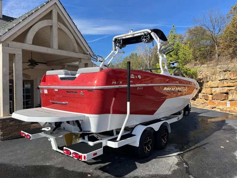 Slide: The Image of 2025 Moomba Max boat in red, parked on a trailer near a house. - 3