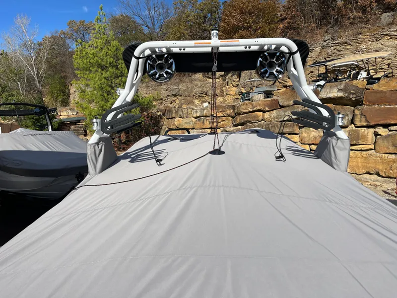 Slide: The Image of 2025 Moomba Max boat with cover, featuring wakeboard tower and speakers, set against a rocky landscape. - 6