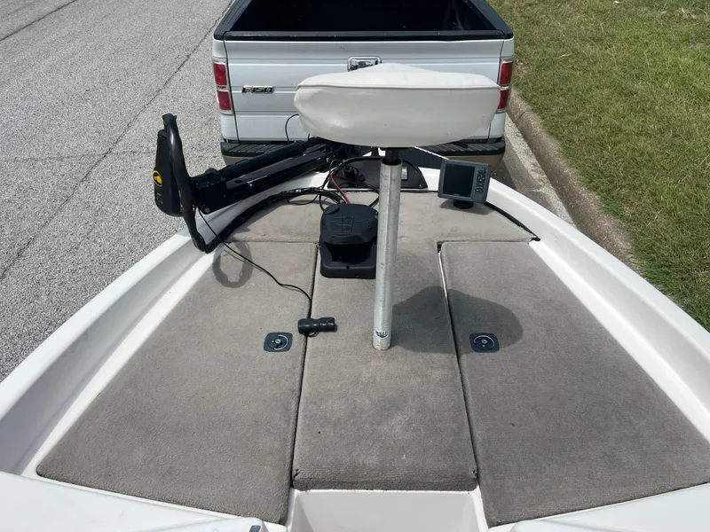 Slide: The Image of 1998 Skeeter 176 SL C boat deck with fishing seat and equipment, parked near a white truck. - 45