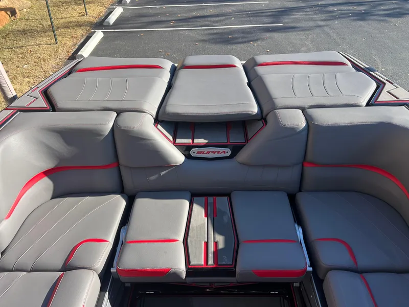 Slide: The Image of 2022 Supra SE boat interior with gray and red seating, showcasing modern design. - 11