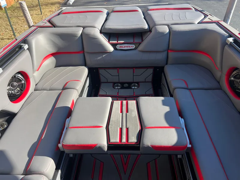 Slide: The Image of 2022 Supra SE boat interior with gray and red seating, premium sound system. - 13