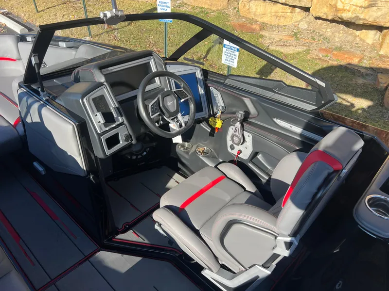 Slide: The Image of 2022 Supra SE boat interior with modern dashboard and gray-red seating. - 17