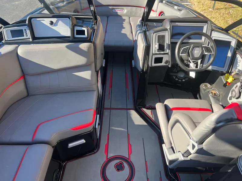 Slide: The Image of 2022 Supra SE boat interior with modern dashboard, gray and red seating, and sleek design. - 18