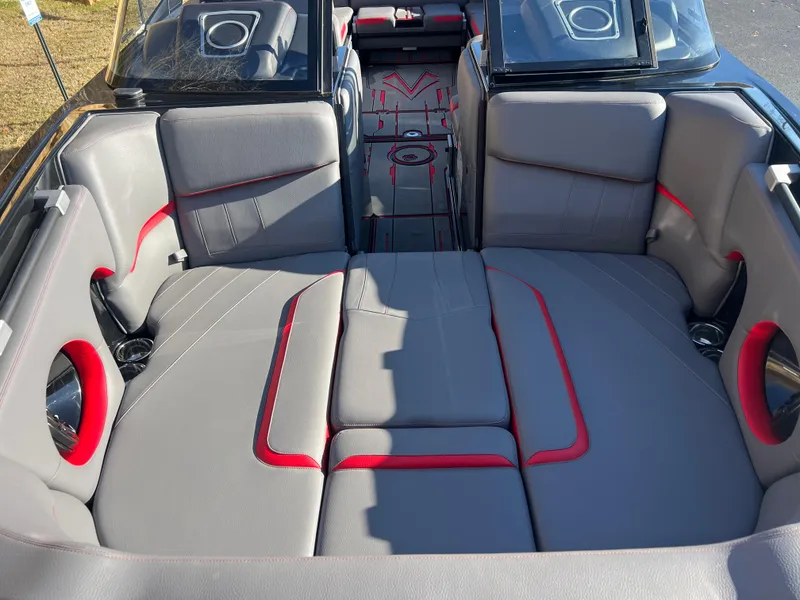 Slide: The Image of 2022 Supra SE boat interior with gray and red seating, open deck layout. - 19