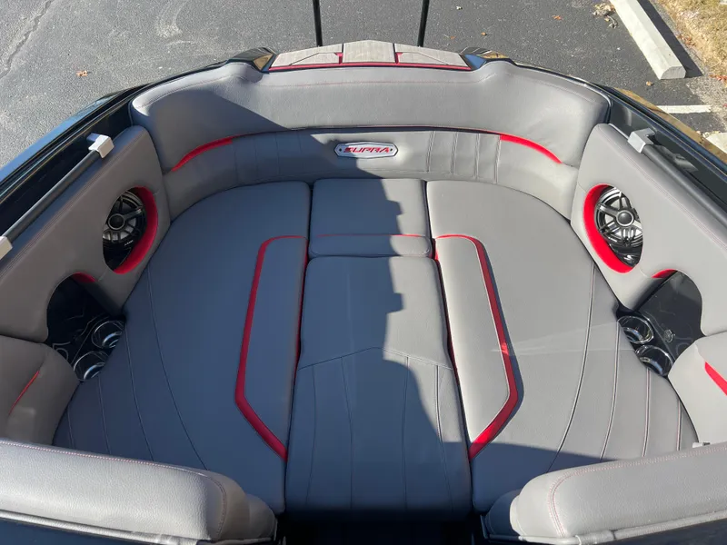 Slide: The Image of 2022 Supra SE boat interior with gray and red seating, featuring built-in speakers. - 20