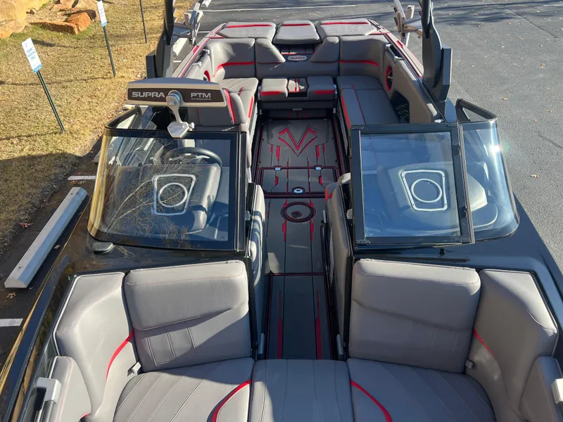 Slide: The Image of 2022 Supra SE boat interior with gray and red seating, open windshield, and modern design. - 26