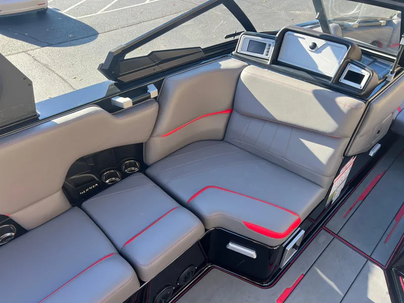 Slide: The Image of 2022 Supra SE boat interior with gray and red seating, modern dashboard. - 27