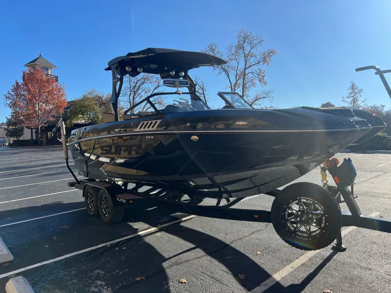 Slide: The Image of 2022 Supra SE boat on trailer in parking lot, sunny day. - 3