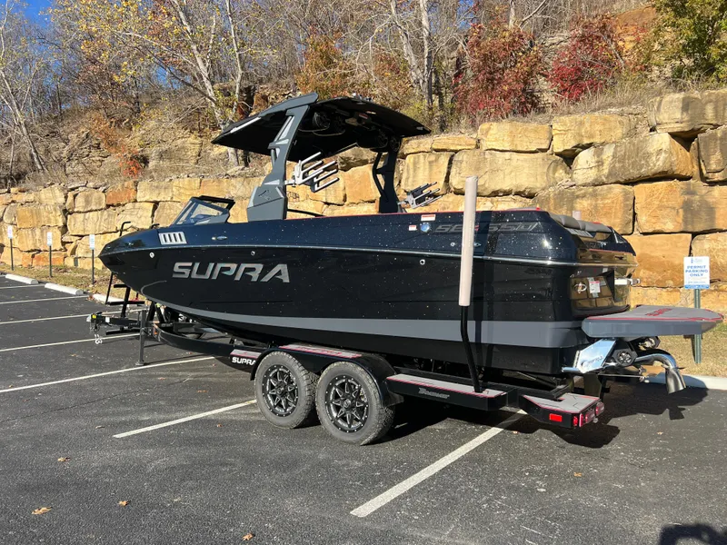 Slide: The Image of 2022 Supra SE boat on trailer in parking lot, surrounded by autumn foliage. - 6