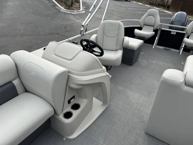 Slide: The Image of 2024 Starcraft LX 20 F pontoon boat interior with plush seating and steering console. - 7