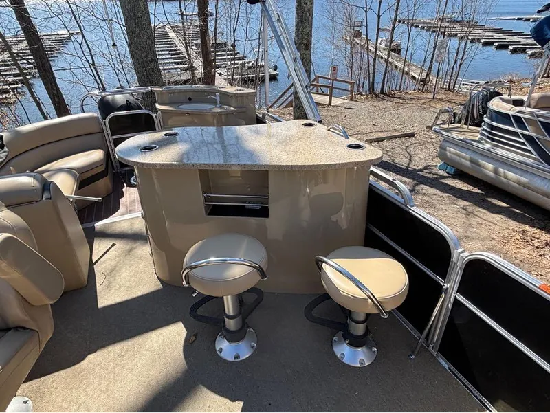 Slide: The Image of 2014 South Bay 523E pontoon boat interior with bar stools and lake view. - 12