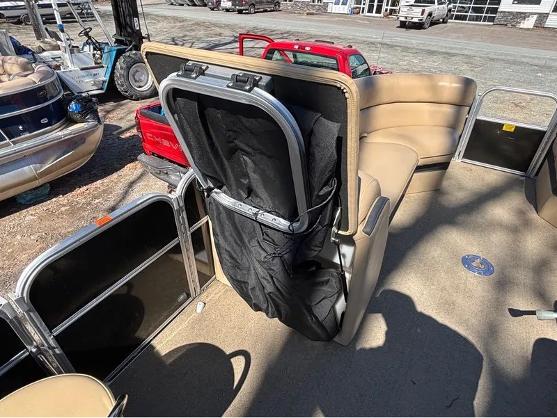 Slide: The Image of 2014 South Bay 523E pontoon boat interior with beige seating and storage compartment. - 4