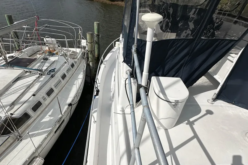 Slide: The Image of 1998 Mainship 350 Trawler docked beside another boat, showcasing deck and railing. - 22