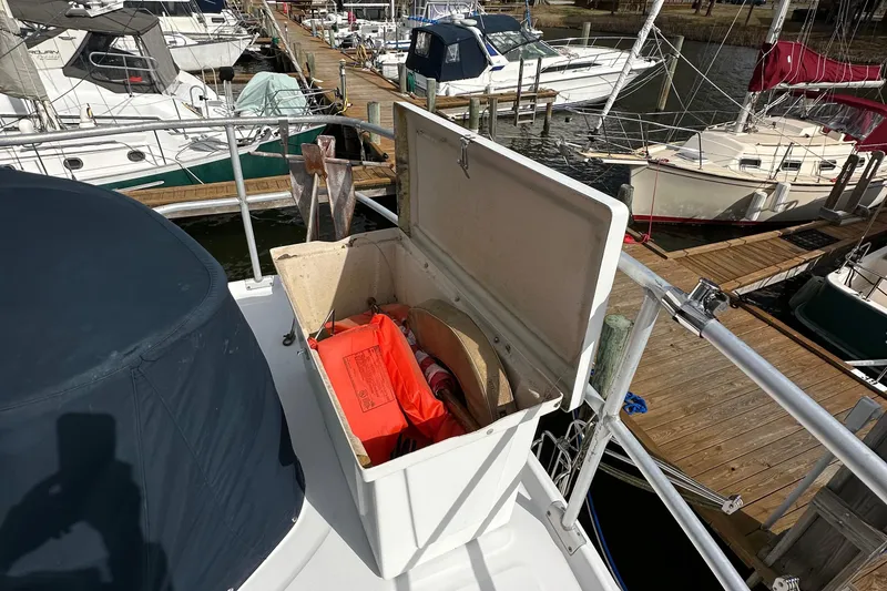 Slide: The Image of 1998 Mainship 350 Trawler with open storage compartment, docked at marina. - 23