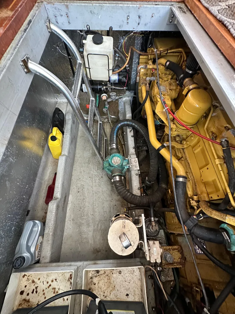 Slide: The Image of Engine compartment of a 1998 Mainship 350 Trawler, showcasing mechanical components and wiring. - 28