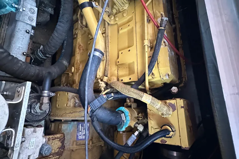 Slide: The Image of Engine compartment of a 1998 Mainship 350 Trawler, showcasing hoses and mechanical components. - 33