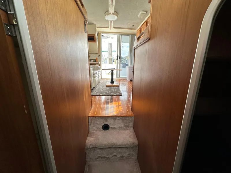 Slide: The Image of Interior view of 1998 Mainship 350 Trawler, featuring wooden paneling and carpeted steps. - 38