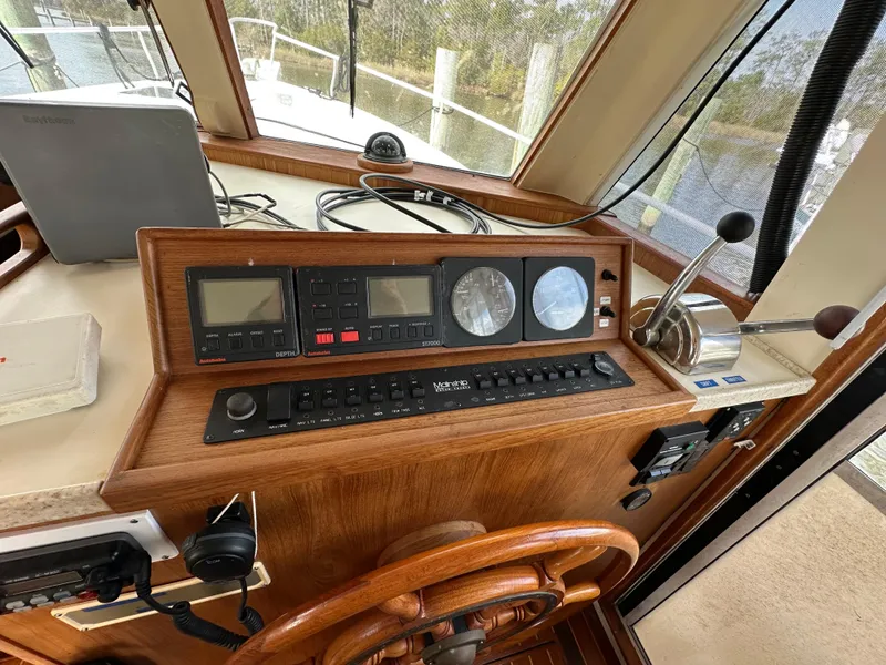 Slide: The Image of 1998 Mainship 350 Trawler helm with navigation instruments and wooden steering wheel. - 39