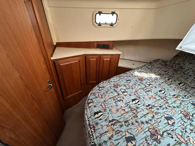Slide: The Image of 1998 Mainship 350 Trawler cabin with wood cabinetry and patterned bedding. - 40