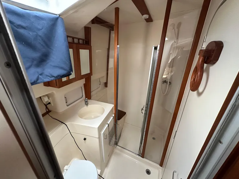 Slide: The Image of 1998 Mainship 350 Trawler bathroom with shower, sink, and wooden accents. - 41