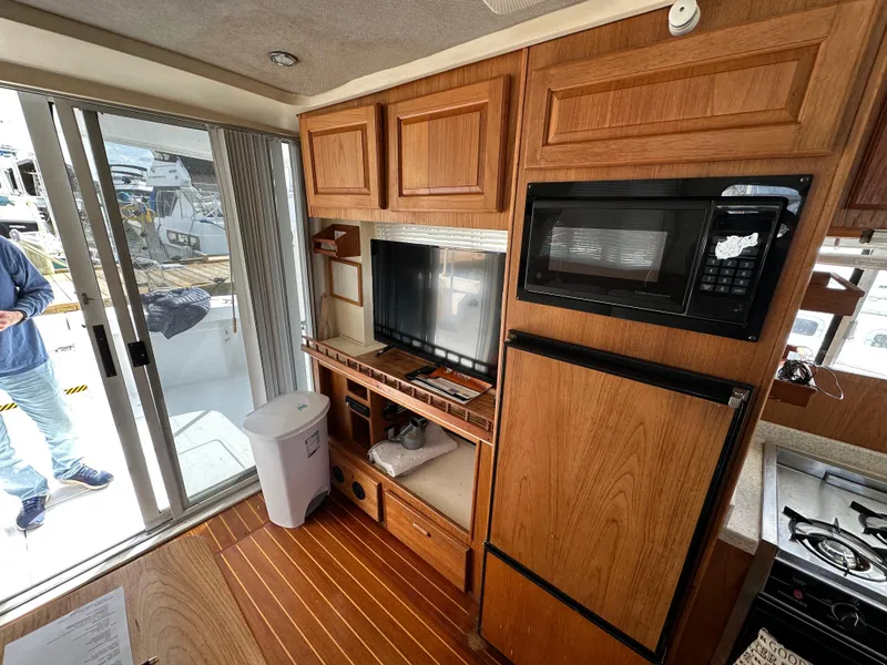 Slide: The Image of Interior of 1998 Mainship 350 Trawler with wood cabinetry, microwave, and sliding glass door. - 45