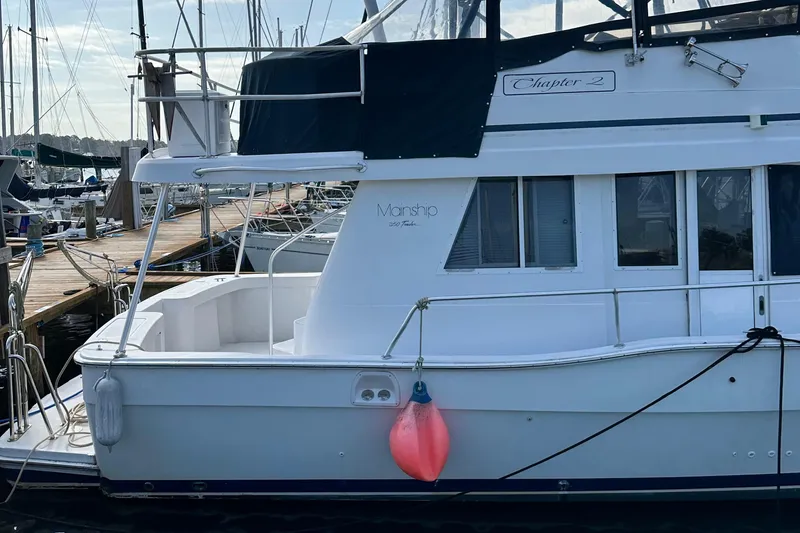 Slide: The Image of 1998 Mainship 350 Trawler docked at marina with visible fender and windows. - 8