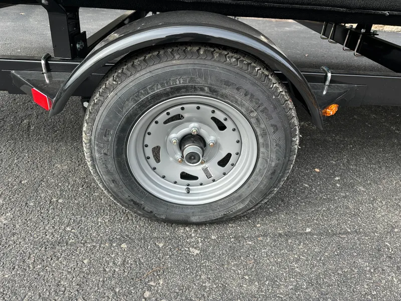 Slide: The Image of Trailer wheel of 2024 Starcraft LX 20 CB on asphalt surface. - 17
