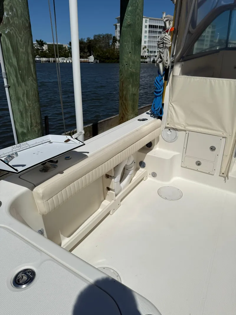 Slide: The Image of 2011 World Cat 320 EC boat interior, featuring seating and storage, docked by the water. - 20
