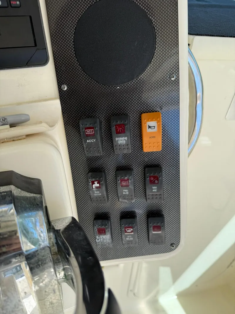 Slide: The Image of Control panel of a 2011 World Cat 320 EC boat with labeled switches. - 38