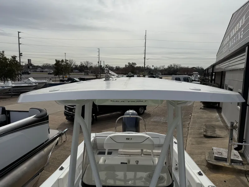 Slide: The Image of 2015 Sea Hunt 225 Ultra boat with T-top in a marina setting. - 10