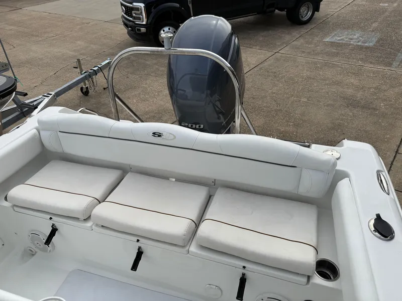 Slide: The Image of 2015 Sea Hunt 225 Ultra boat interior with cushioned seating and outboard motor. - 5