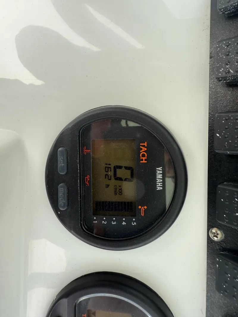 Slide: The Image of Yamaha tachometer on 2015 Sea Hunt 225 Ultra boat dashboard, displaying 162 hours. - 8