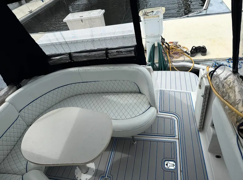 Slide: The Image of Interior of 2002 Four Winns 268 Vista with seating and table, docked by water. - 14