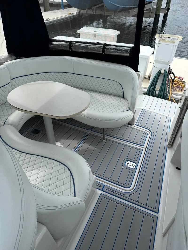 Slide: The Image of Luxury seating area on a 2002 Four Winns 268 Vista boat, featuring elegant upholstery and a sleek table. - 15