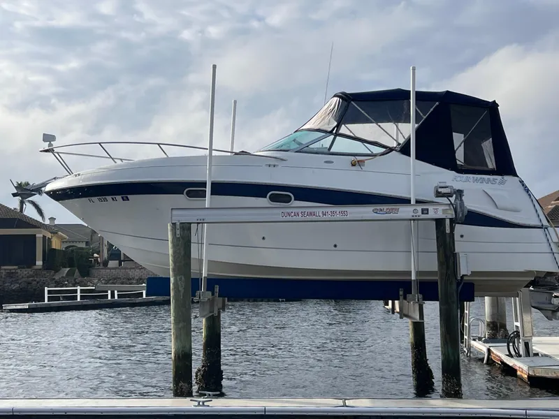 Slide: The Image of Four Winns 268 Vista 2002 boat on lift, water background, motor replaced in 2023. - 2