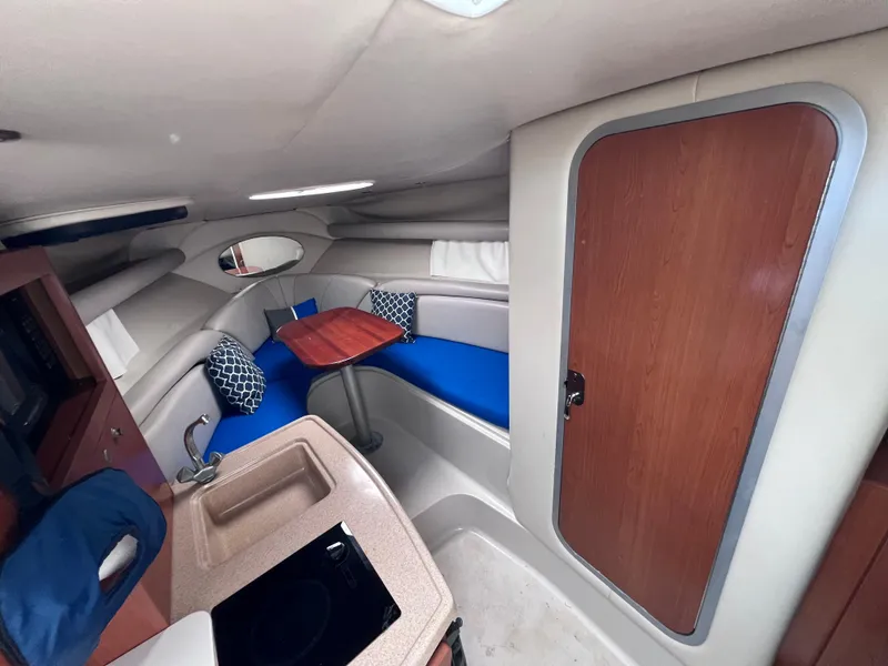 Slide: The Image of Interior of 2002 Four Winns 268 Vista with blue seating and wooden accents. - 22