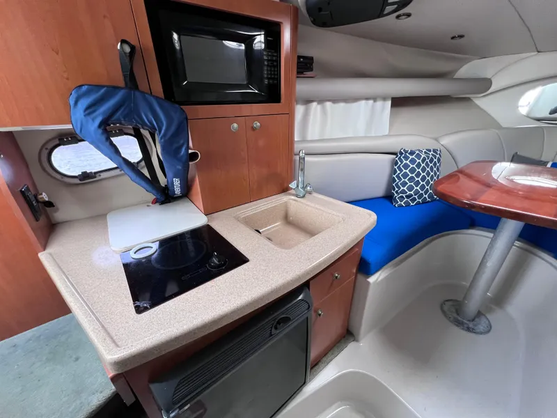 Slide: The Image of Interior of 2002 Four Winns 268 Vista boat with kitchenette and seating area. - 23