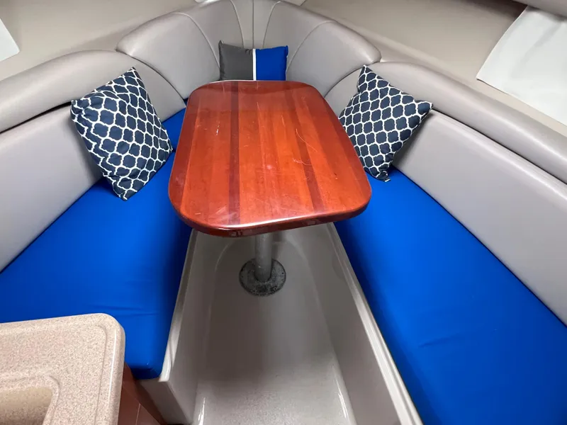 Slide: The Image of Interior of 2002 Four Winns 268 Vista with blue seating and wooden table. - 24