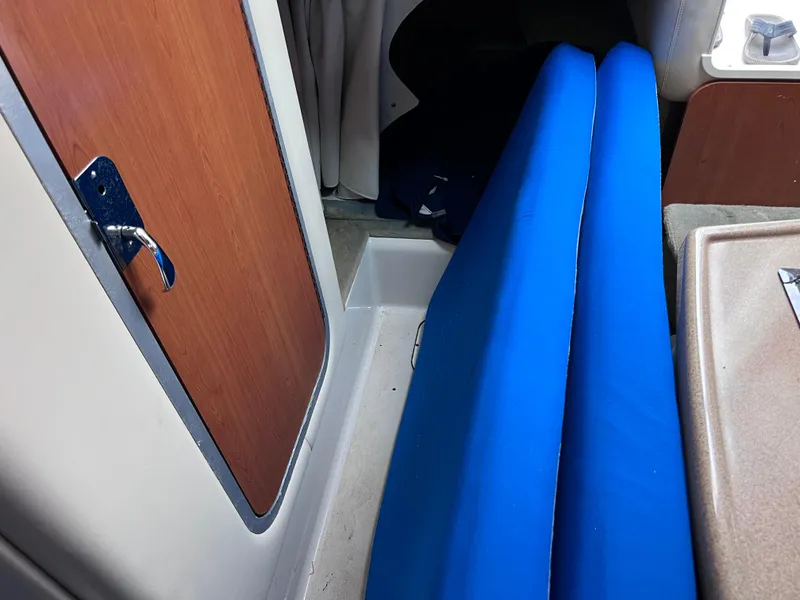 Slide: The Image of Interior of 2002 Four Winns 268 Vista with blue cushions and wooden door. - 30