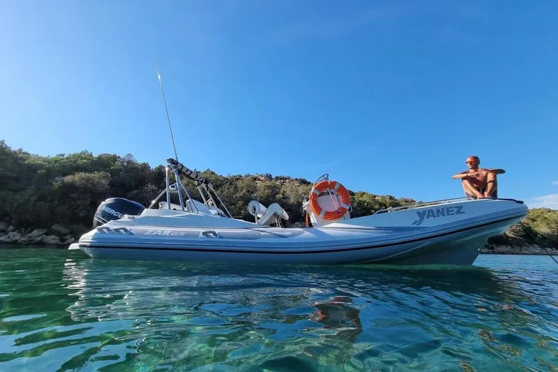 The Image of Zar Formenti 65 Suite 2027 boat on clear water, with a person seated on the bow. - 0