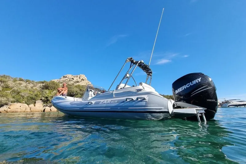 Slide: The Image of Zar Formenti 65 Suite 2027 boat with Mercury engine on clear blue water. - 1
