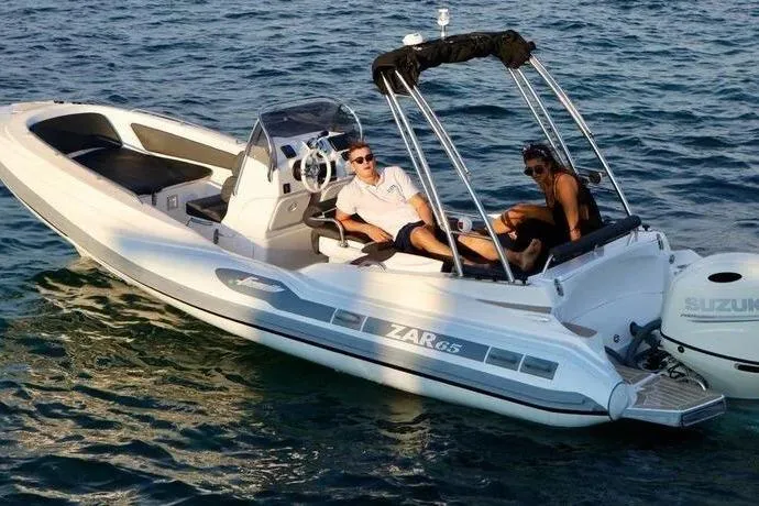 Slide: The Image of 2027 Zar Formenti 65 Suite boat with two people relaxing on the water. - 2