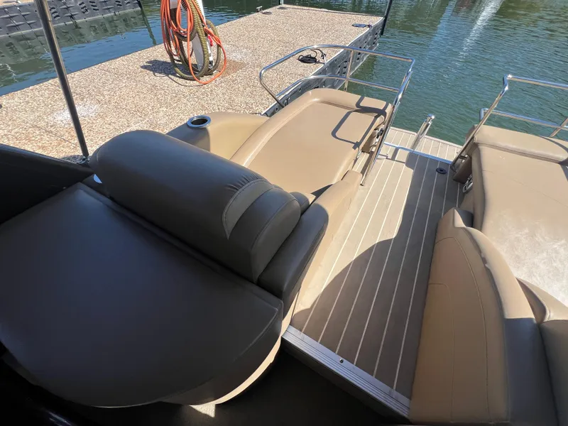 Slide: The Image of 2016 Bennington 2552 QCW I/O boat interior with tan seating and deck view. - 11