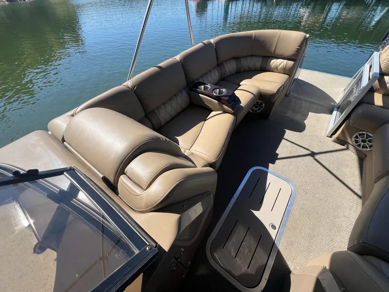Slide: The Image of 2016 Bennington 2552 QCW I/O boat with luxurious tan seating and cup holders on a sunny day. - 18