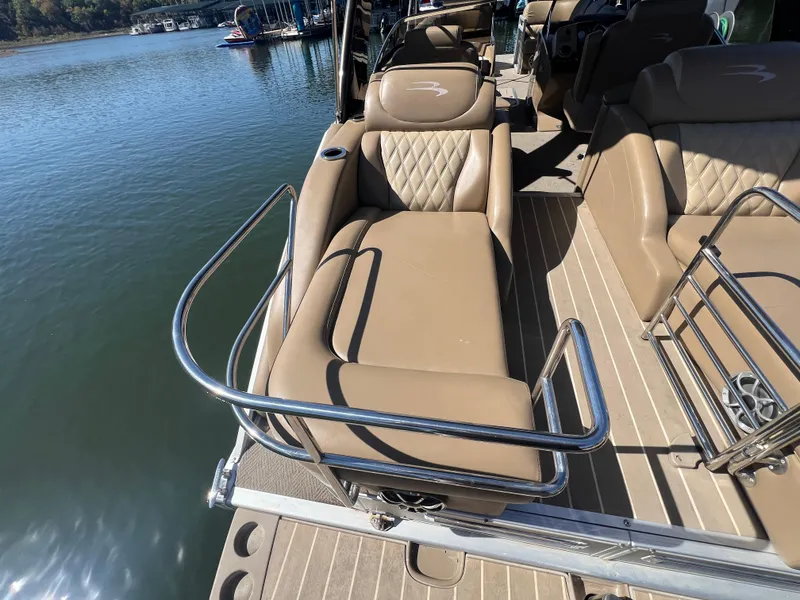 Slide: The Image of 2016 Bennington 2552 QCW I/O boat with tan seating and stainless steel railings. - 22