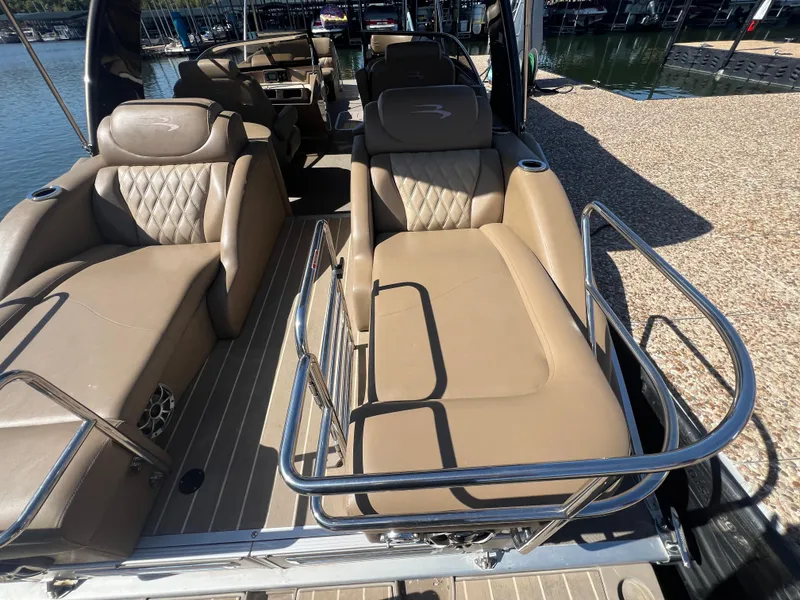 Slide: The Image of 2016 Bennington 2552 QCW I/O boat interior with tan seating and stainless steel railings. - 23