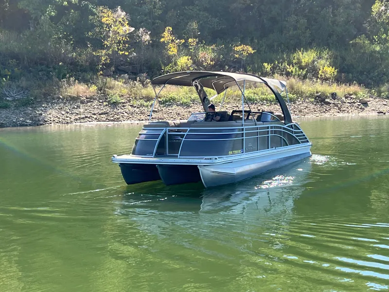 Slide: The Image of 2016 Bennington 2552 QCW I/O pontoon boat cruising on a calm lake. - 3